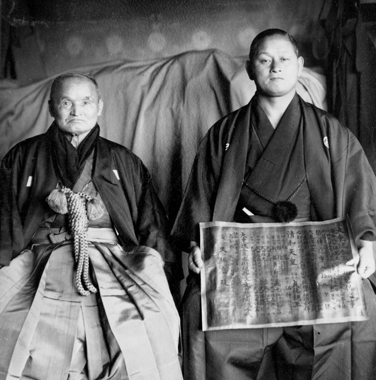 免許皆伝を手に持った久琢磨と武田惣角。
